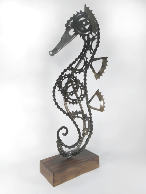 Artesanía realizada con materiales reciclados de repuestos de bicicletas y hierro de contrucción. Está pavonada para proteger a la misma del paso del tiempo. La base tiene el proceso de quemado y luego está encerada, además se puede retirar girando... para un fácil traslado. No te lo pierdas!!! Pieza única!
