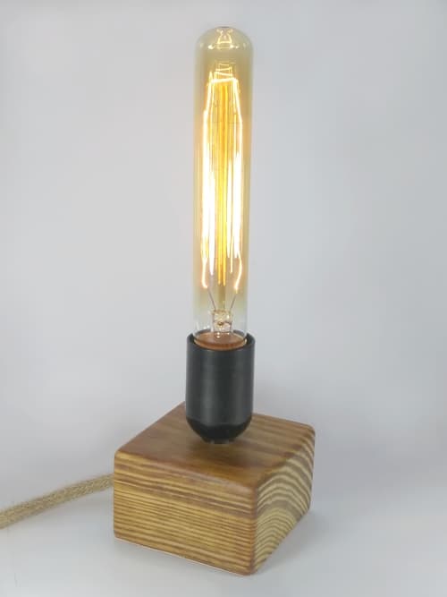 Lámpara decorativa de madera de pinotea trabajada de forma artesanal y manualmente. Base antideslizante de cuerina. Embellecida con cera natural y cable de yute. Ilumina y decora!