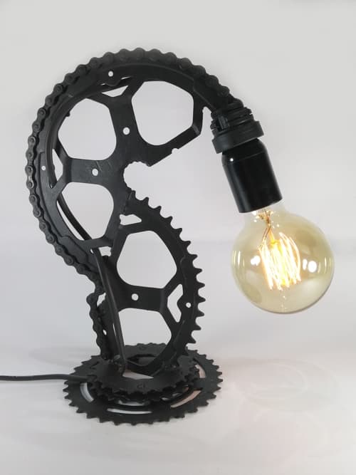 Lámpara estilo industrial. Un plato de bici, más una parte de piñón y un trozo de cadena forman ésta pieza única. Ni pesada, ni liviana, perfecta por dónde se la mire, y viene con una lámpara globo!