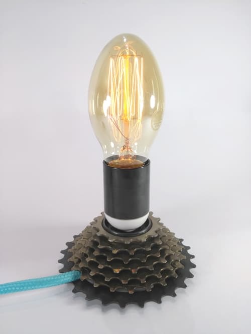 Un hermoso piñón de bici reciclado hace que esta lámpara sea única, por su cable textil y por su portalámparas de dos colores, combinable con el enchufe y el interruptor. No te la pierdas!