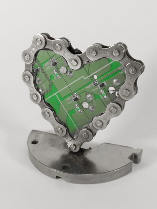 Corazón realizado con cadena de bici reciclada y con el circuito electrónico de un teclado sin funcionar. La base es de acero templado!