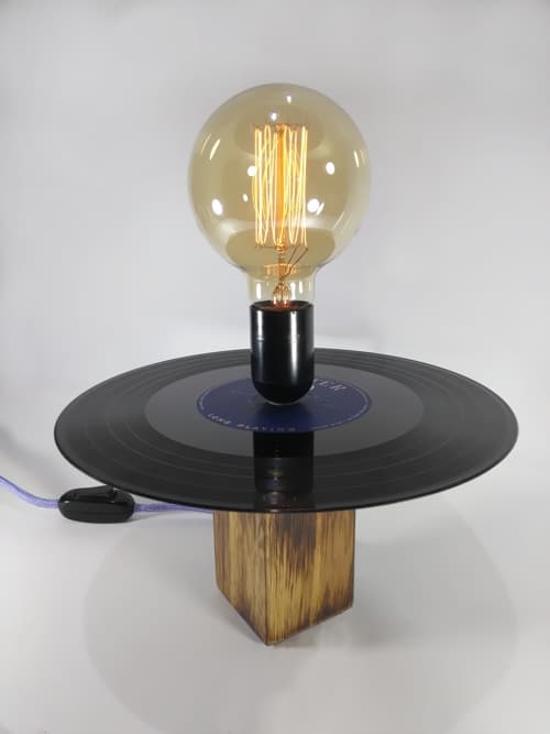 Lámpara decorativa en madera de kiri, trabajada con efecto quemado, lijada y encerada. La combinación del cable textil lila junto con el interruptor y el portalámparas negro hacen de esta lámpara algo único. No la dejes pasar!