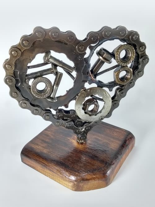Realizado con piezas recicladas y madera recuperada. Posee 28 eslabones de una cadena de bici.