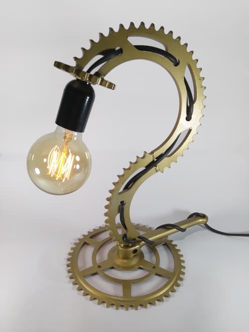 Lámpara de estilo industrial. Dos repuestos de moto y uno de bici, ambos reciclados, conforman esta pieza dorada única.