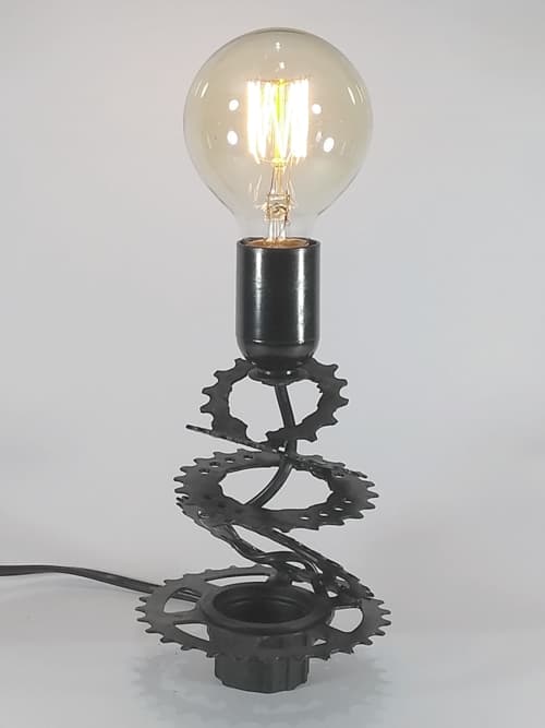 Lámpara decorativa realizada con un piñón de bicicleta reciclado pintado a mano color negro mate. Portalámparas de baquelita y cable negro. La lámpara pequeña y versátil no pasará desapercibida en ningún lugar de tu hogar!!! 